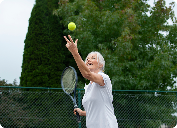 Active senior woman playing tennis, representing improved mobility from joint care treatment